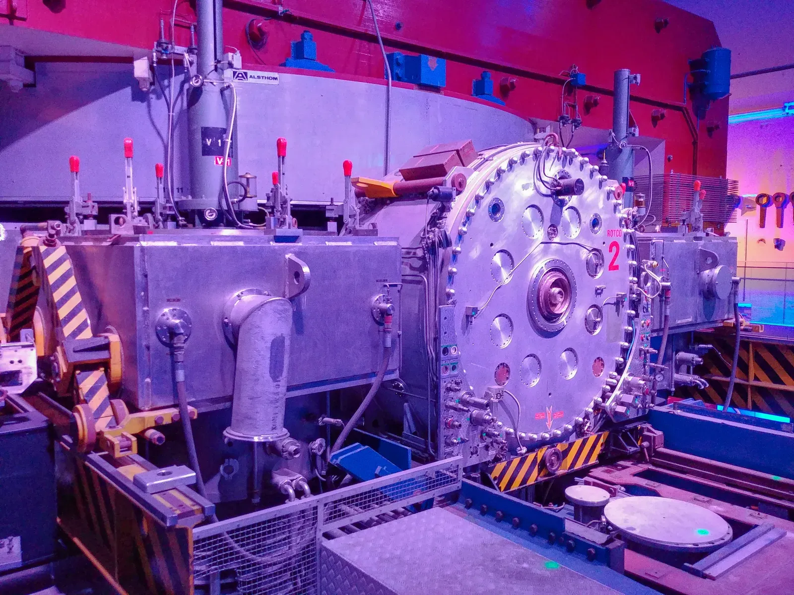 The Synchrocyclotron, CERN's first accelerator, lit up in a dark room.